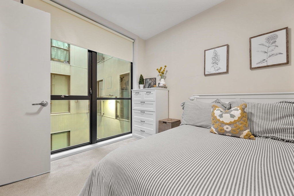 121 Portland Street, Unit 605 Boston, MA 02114 - Photo 14 of 19 a bedroom with a bed and a cabinets