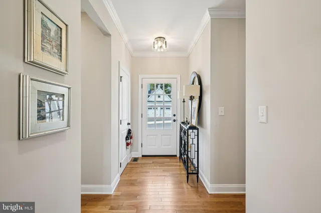 a view of a hallway with wooden floor and closet