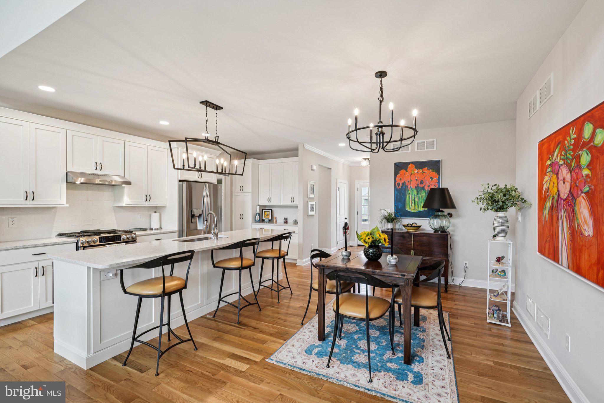 4459 Old Saucon Road Bethlehem, PA 18015 - Photo 10 of 40 a kitchen with stainless steel appliances granite countertop a stove a refrigerator a kitchen island a dining table and chairs with wooden floor