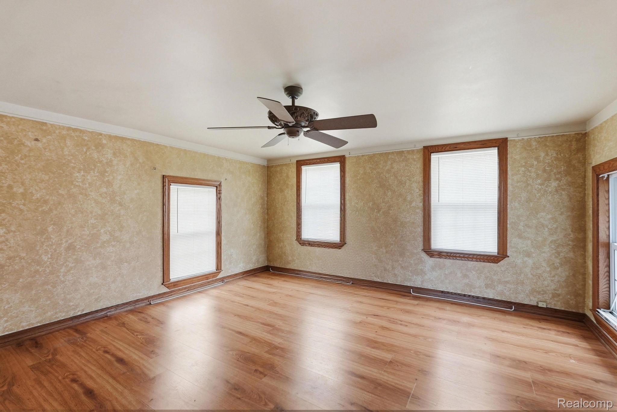 49777 Card Road Macomb, MI 48044 - Photo 8 of 18 Spare room with a ceiling fan, wallpapered walls, light wood-style flooring, and ornamental molding