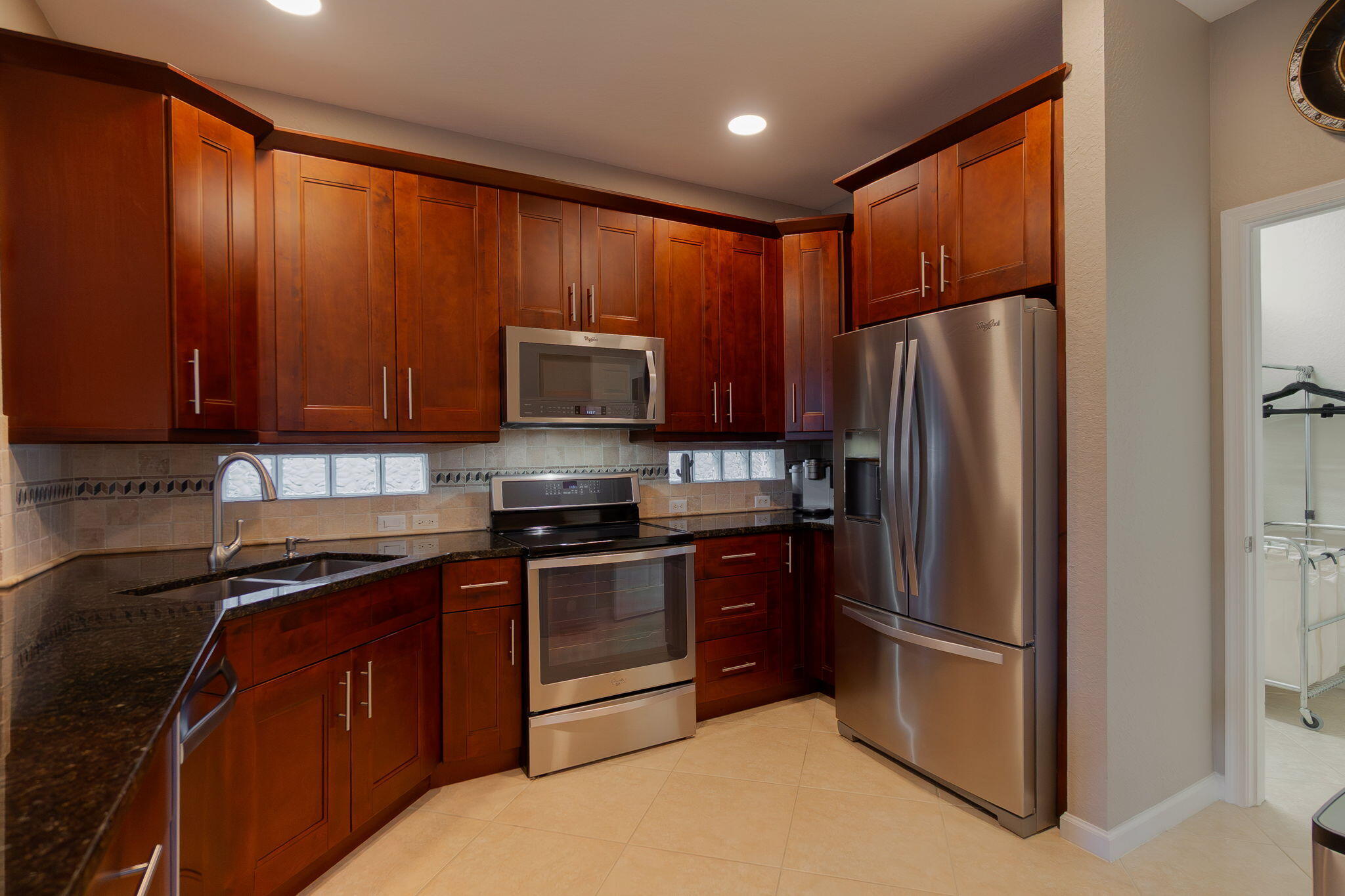 1004 Center Stone Lane Riviera Beach, FL 33404 - Photo 16 of 47 a kitchen with stainless steel appliances granite countertop a refrigerator stove microwave and sink