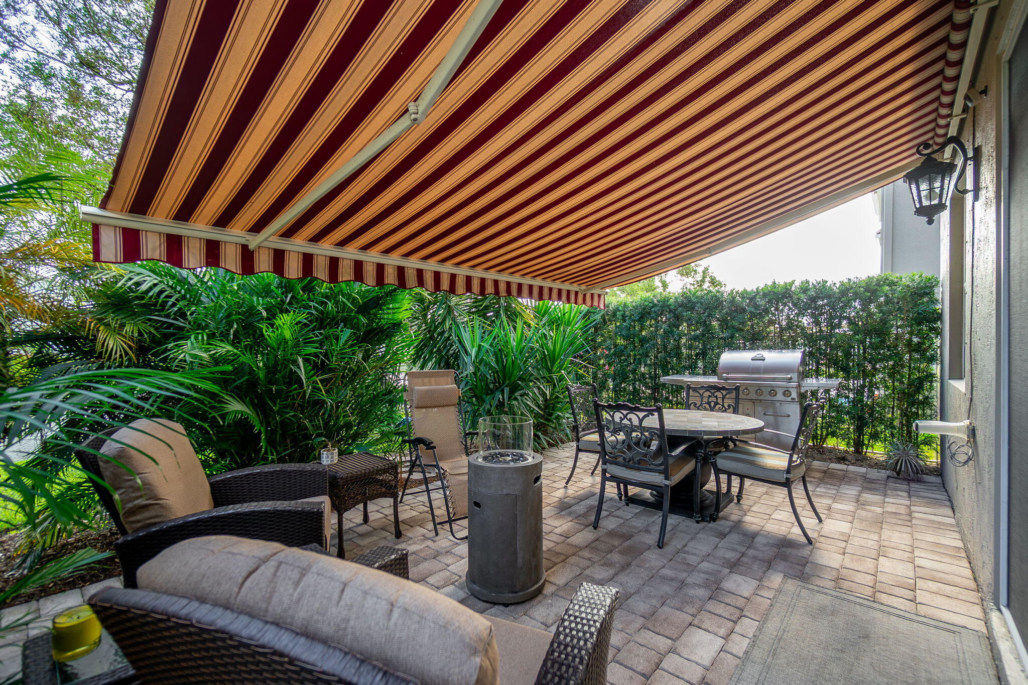 1004 Center Stone Lane Riviera Beach, FL 33404 - Photo 35 of 47 a patio with a table and chairs and potted plants