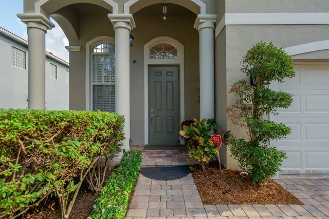 a front view of a house with a lots of flower garden