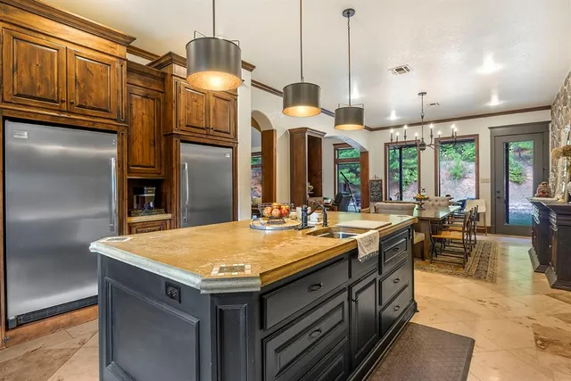 a kitchen with a stove a refrigerator a oven and a dining table with wooden floor