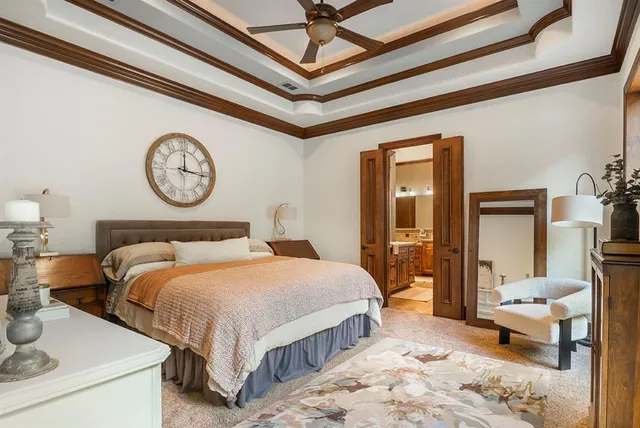 a bedroom with a bed a mirror and a table with wooden floor