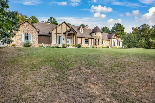 a view of a big house with a big yard and large trees