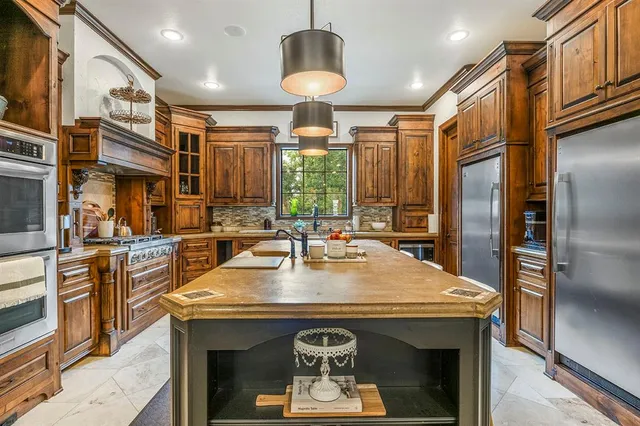 a kitchen with stainless steel appliances granite countertop a stove a refrigerator and a stove