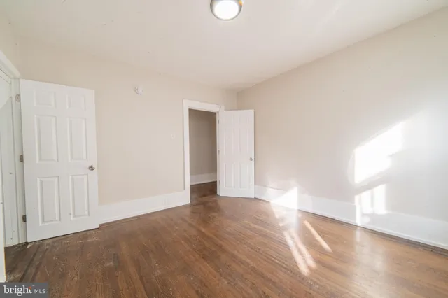 a view of an empty room and window with wooden floor