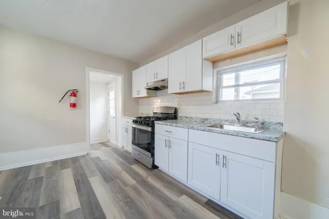 a kitchen with granite countertop white cabinets and white appliances