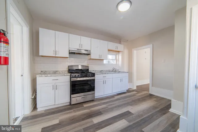 a kitchen with a white stove top oven and cabinets