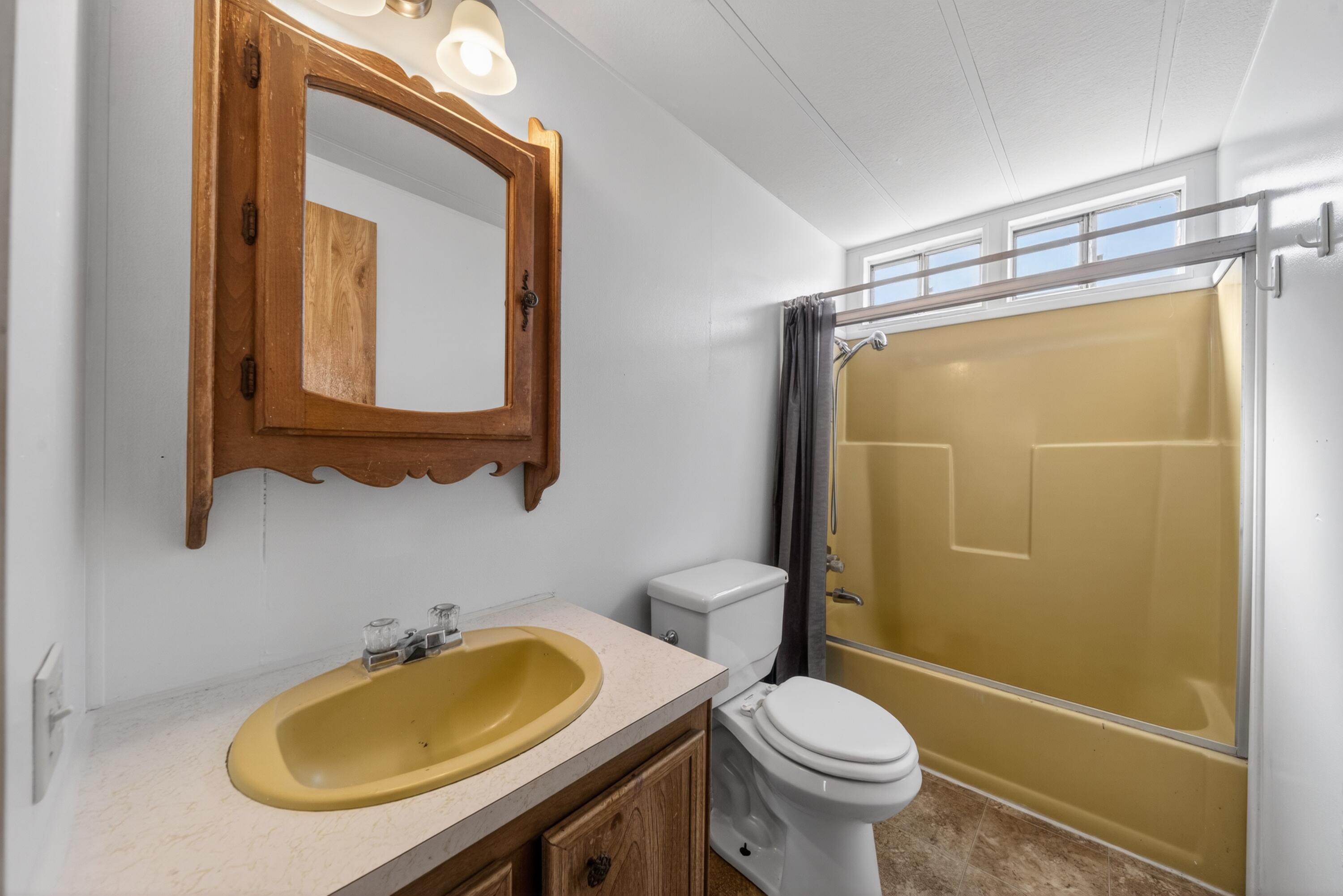 21133 Ronald Street Anderson, CA 96007 - Photo 23 of 26 a bathroom with a granite countertop toilet sink and mirror