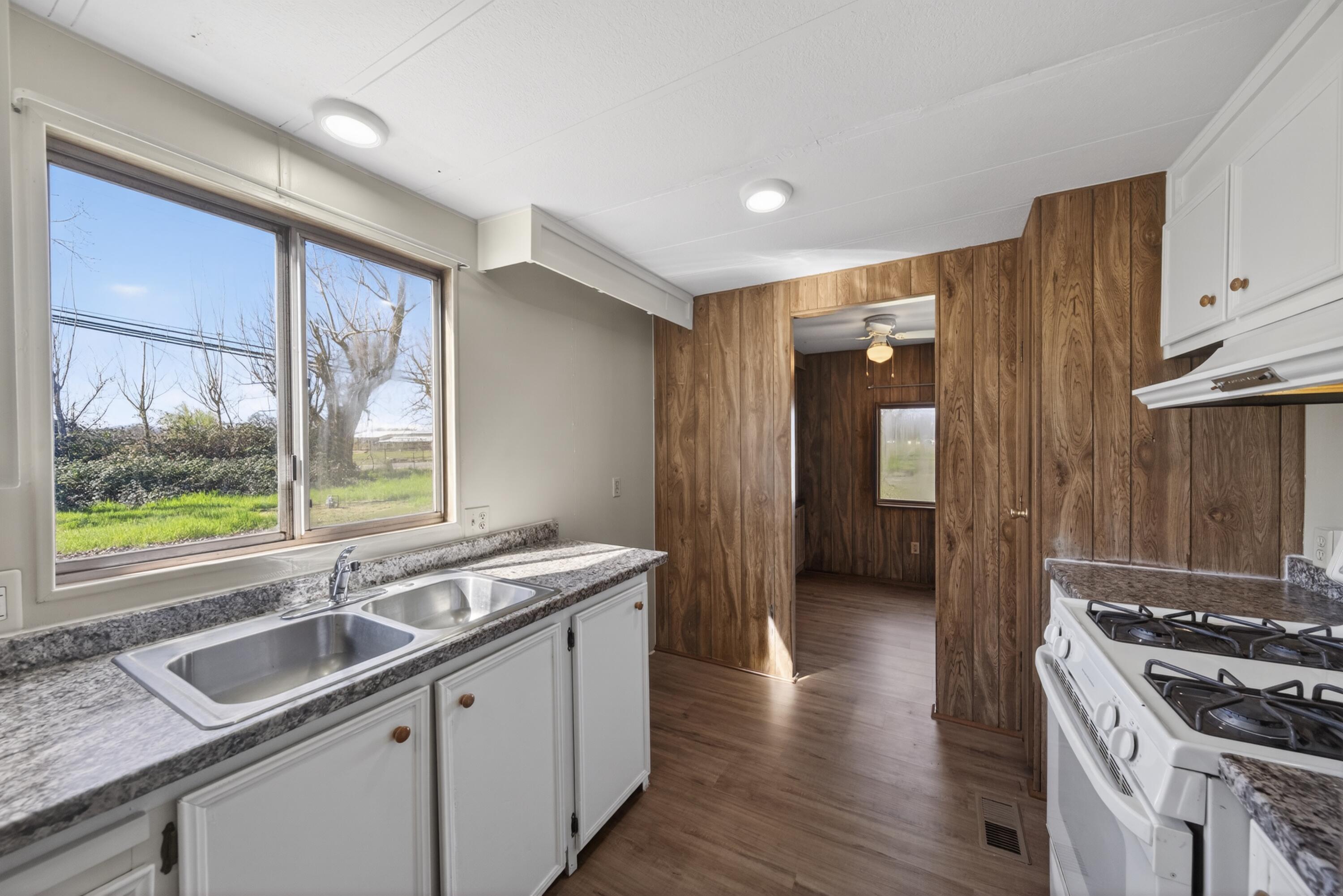 21133 Ronald Street Anderson, CA 96007 - Photo 9 of 26 a kitchen with granite countertop a sink and a stove