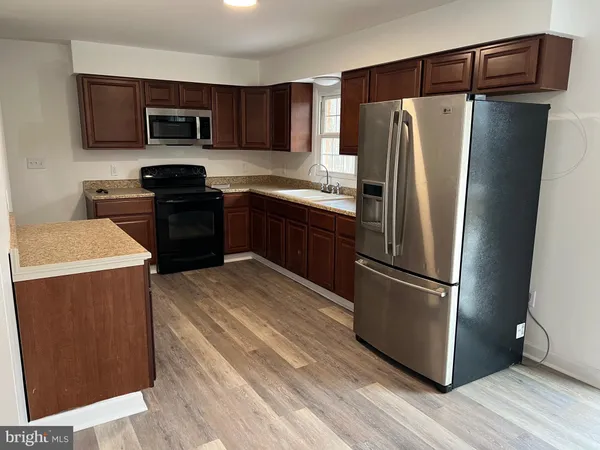 a kitchen with stainless steel appliances a refrigerator stove and microwave