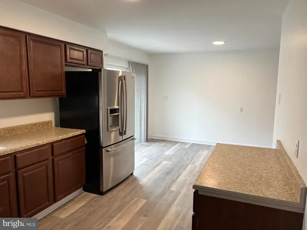 a kitchen with granite countertop a refrigerator and a sink