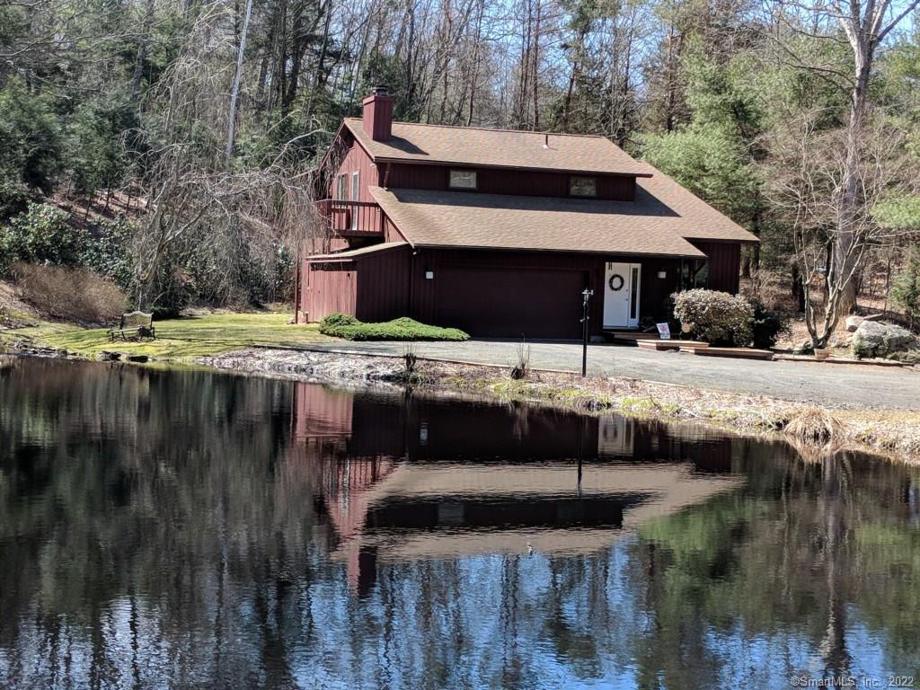 a view of house with yard and sitting area