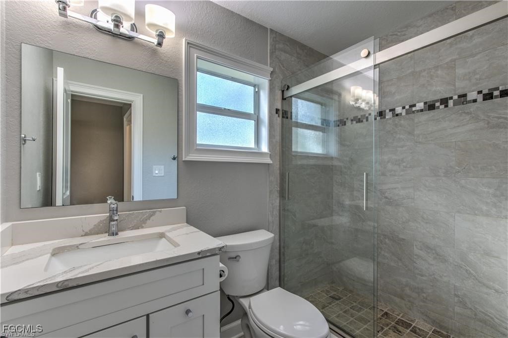 20051-071 Welborn Road North Fort Myers, FL 33917 - Photo 26 of 35 a bathroom with a granite countertop sink toilet and shower