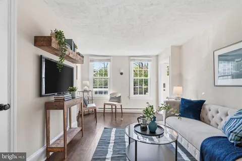 a living room with furniture flat screen tv and large windows