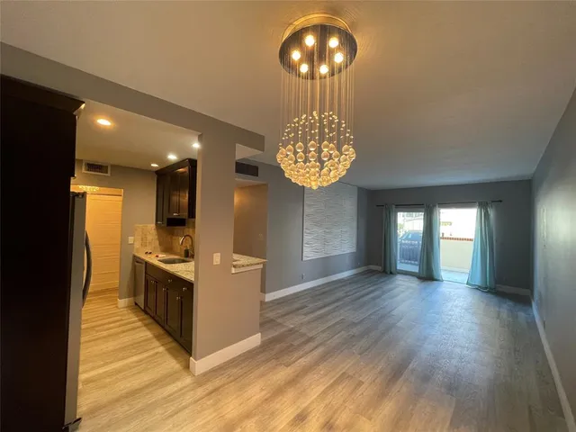 a view of a kitchen with wooden floor and electronic appliances
