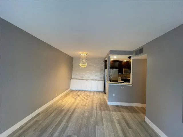 a kitchen with stainless steel appliances kitchen island granite countertop wooden floor and cabinets