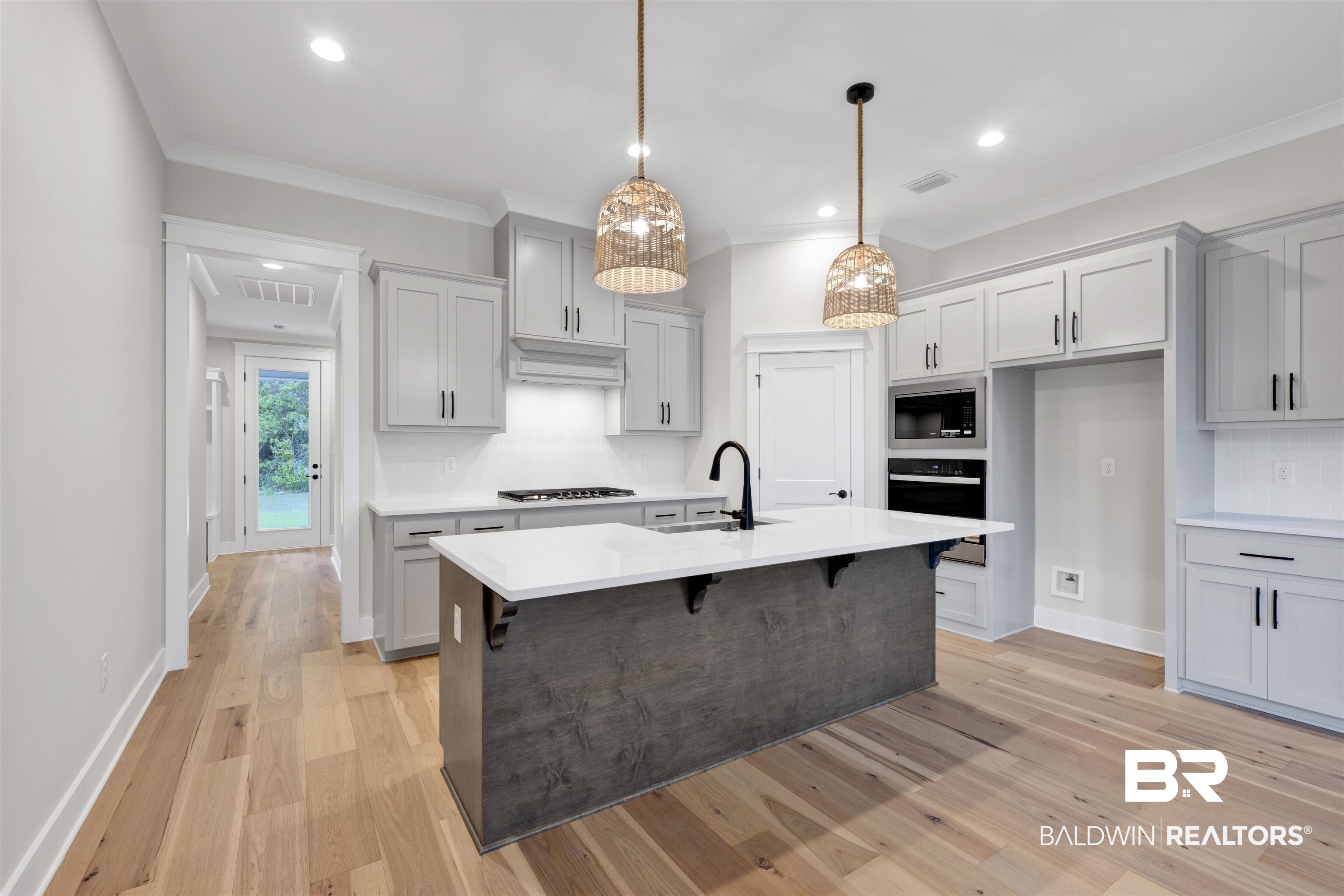 27382 Patch Pl Loop Daphne, AL 36526 - Photo 13 of 31 Kitchen with a kitchen bar, stainless steel appliances, gray cabinetry, light wood-type flooring, and crown molding
