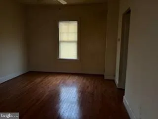 a view of a livingroom with wooden floor and a window