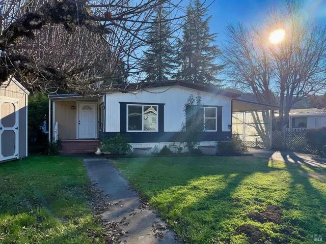 a backyard of a house with fountain table and chairs