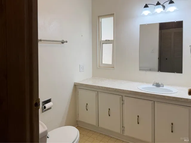 a bathroom with a toilet sink and mirror