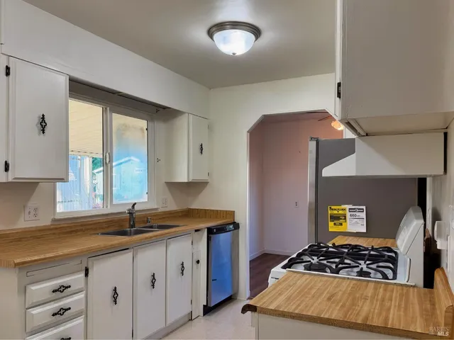a kitchen with granite countertop a stove and a sink