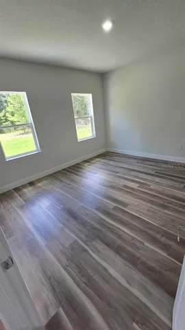 a view of a room with wooden floor and a window