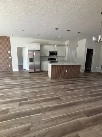 a kitchen with stainless steel appliances kitchen island sink refrigerator and microwave