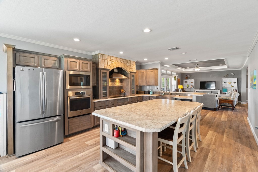 159 Copano Ridge Road Rockport, TX 78382 - Photo 13 of 31 a kitchen with stainless steel appliances granite countertop a refrigerator a stove and a wooden floors