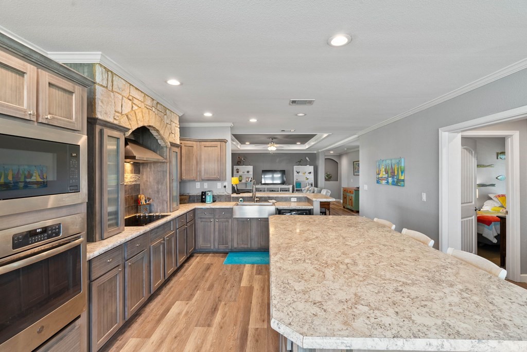 159 Copano Ridge Road Rockport, TX 78382 - Photo 14 of 31 a large kitchen with stainless steel appliances kitchen island granite countertop a large counter top and wooden cabinets