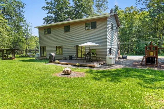 a view of a backyard with a table and chairs under an umbrella