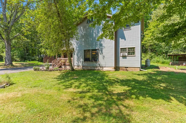 a view of a house with backyard and a tree