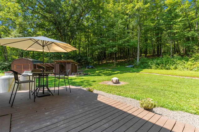 a view of a backyard with table and chairs under an umbrella