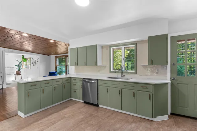a kitchen with a sink cabinets and wooden floor