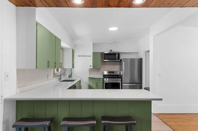 a kitchen with stainless steel appliances a sink and microwave