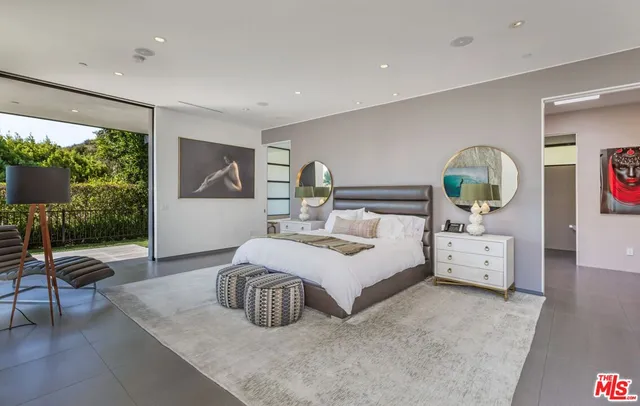 a bedroom with a bed and large windows