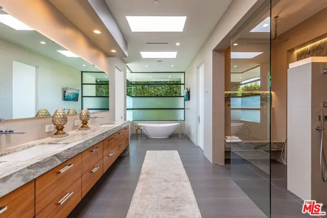 a bathroom with a double vanity sink and a large mirror
