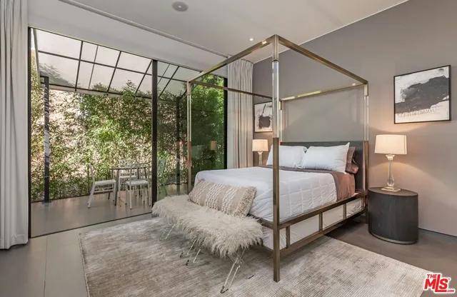 a bedroom with a bed and large window