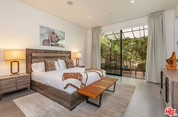 a bedroom with furniture and a large window
