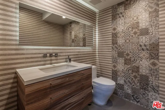 a bathroom with a sink a toilet and a mirror