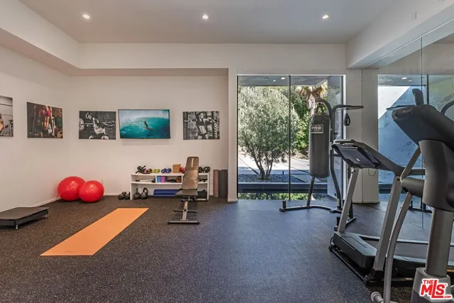 a living room with furniture a window and gym equipment