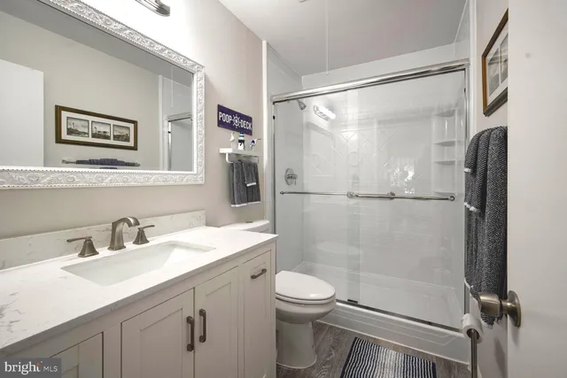 a bathroom with a shower sink vanity mirror and toilet