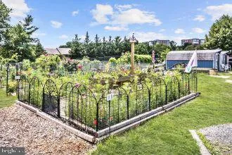 a view of a house with a yard and table and chairs under an umbrella