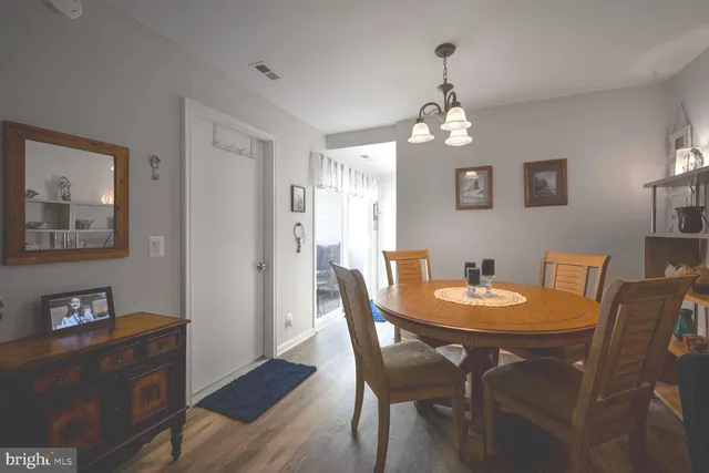 a dining room with furniture a chandelier and wooden floor