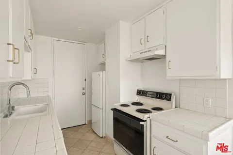 a kitchen with white cabinets and white appliances