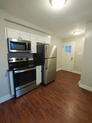 a kitchen with a refrigerator and a stove top oven