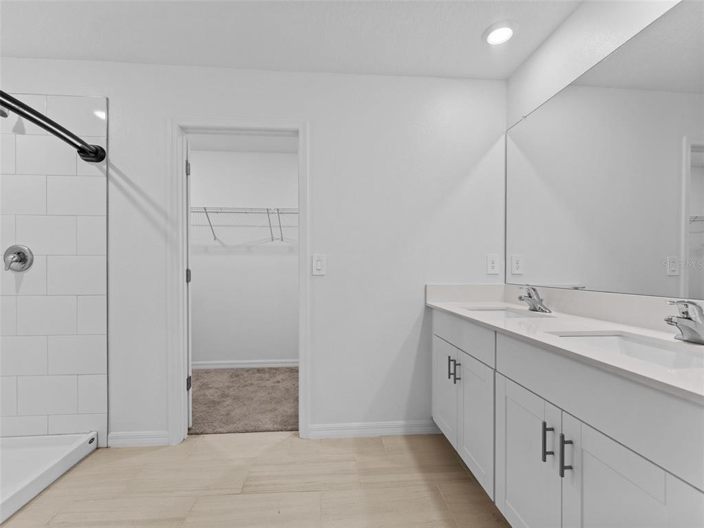 11628 Radiant Shr Loop San Antonio, FL 33576 - Photo 7 of 16 a bathroom with a double vanity sink and mirror