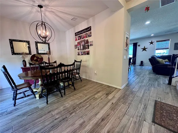 a view of a dining room with furniture wooden floor and chandelier